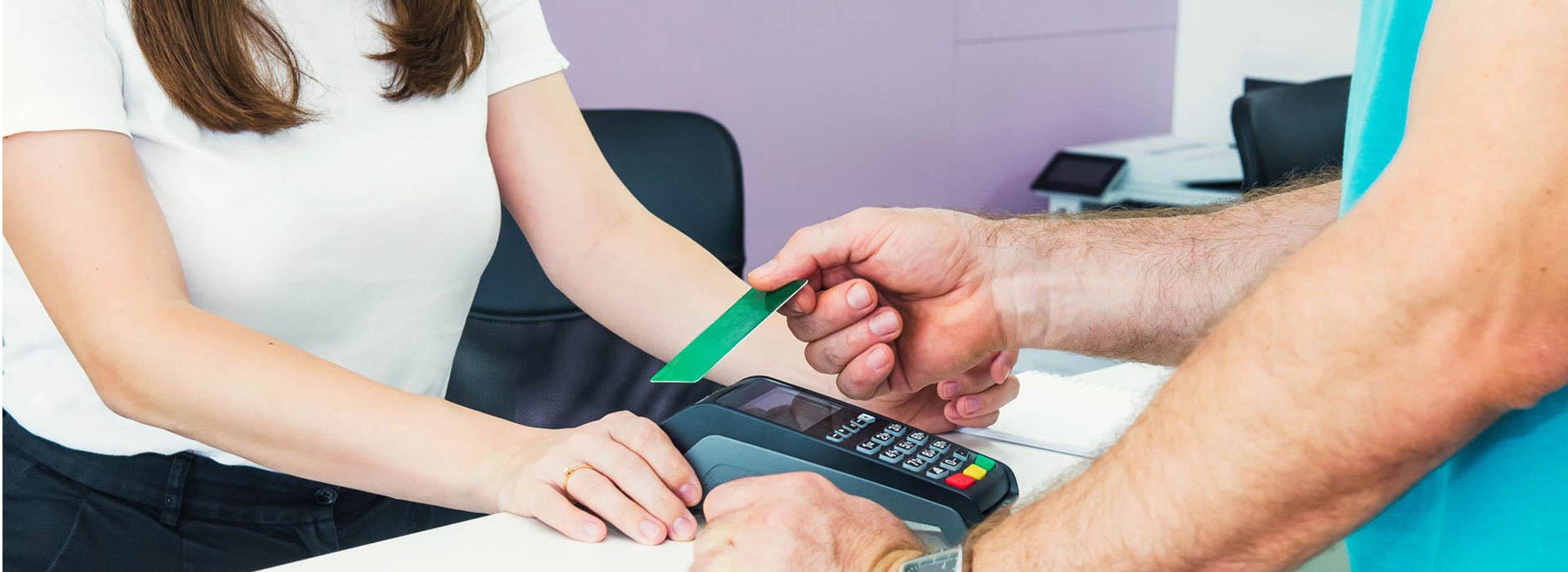 Woman making credit card transaction (holding credit card over processor)