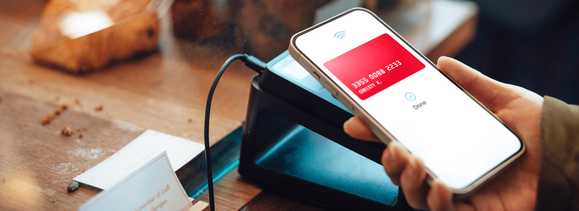 Person holding phone with credit card information visible