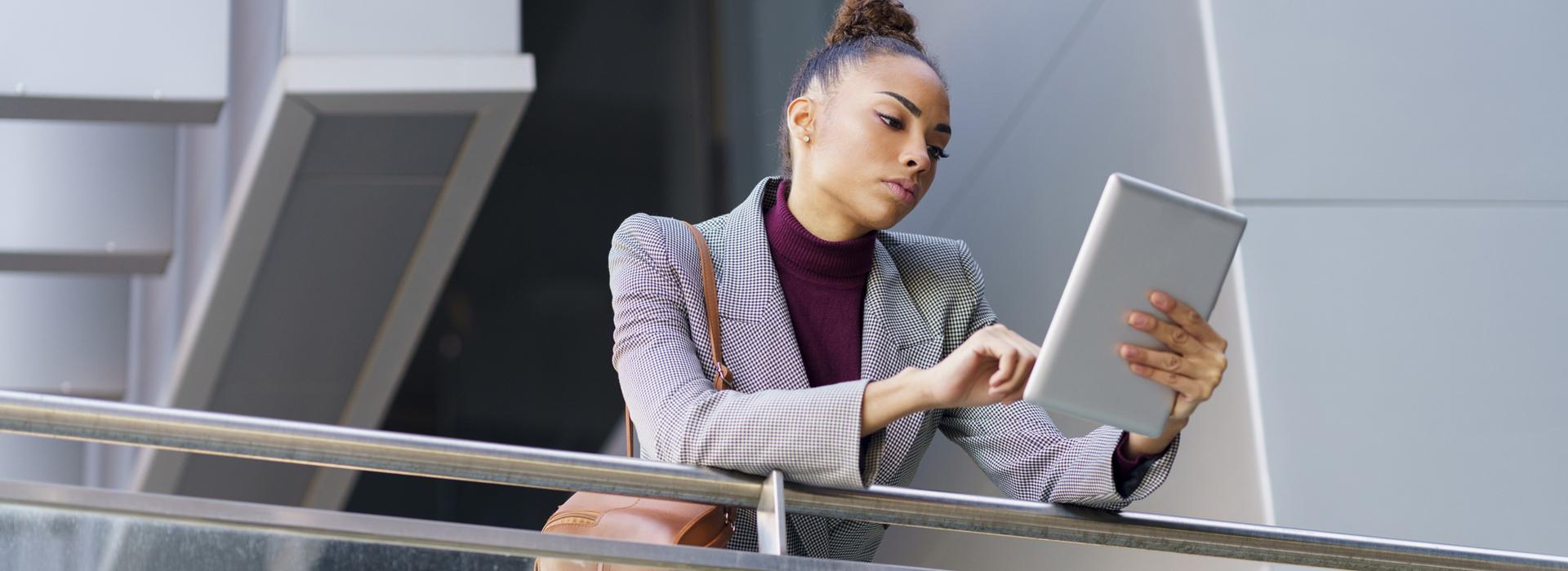 Woman on tablet at railroad station