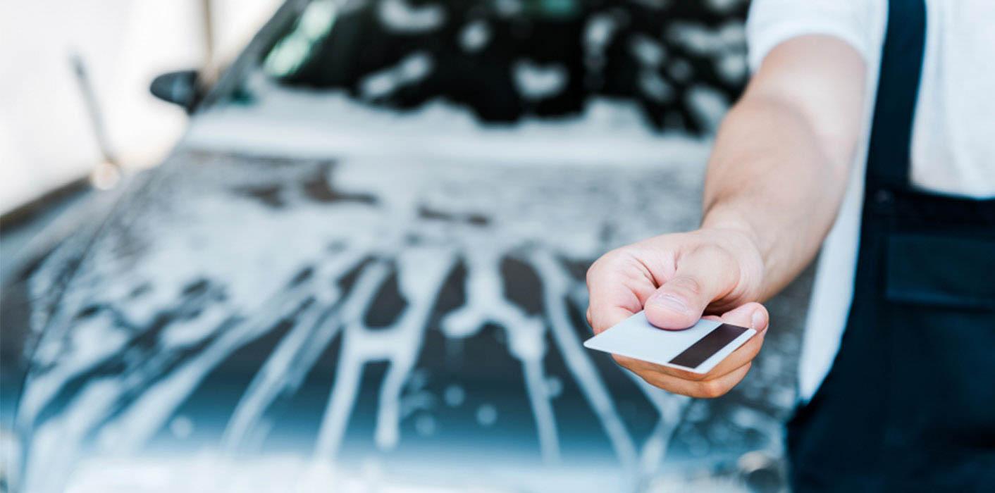 guy holding credit card by car wash