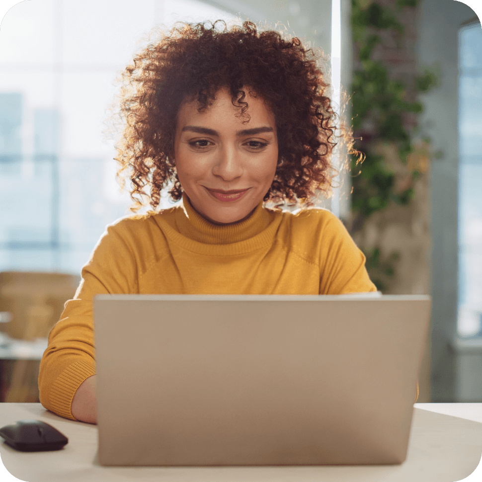 Woman on laptop in yellow top