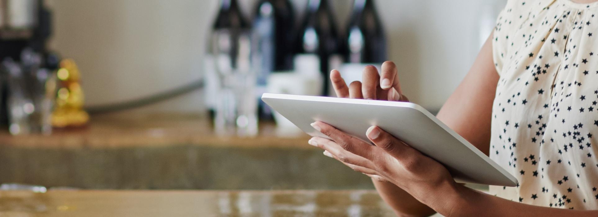 Woman typing on tablet