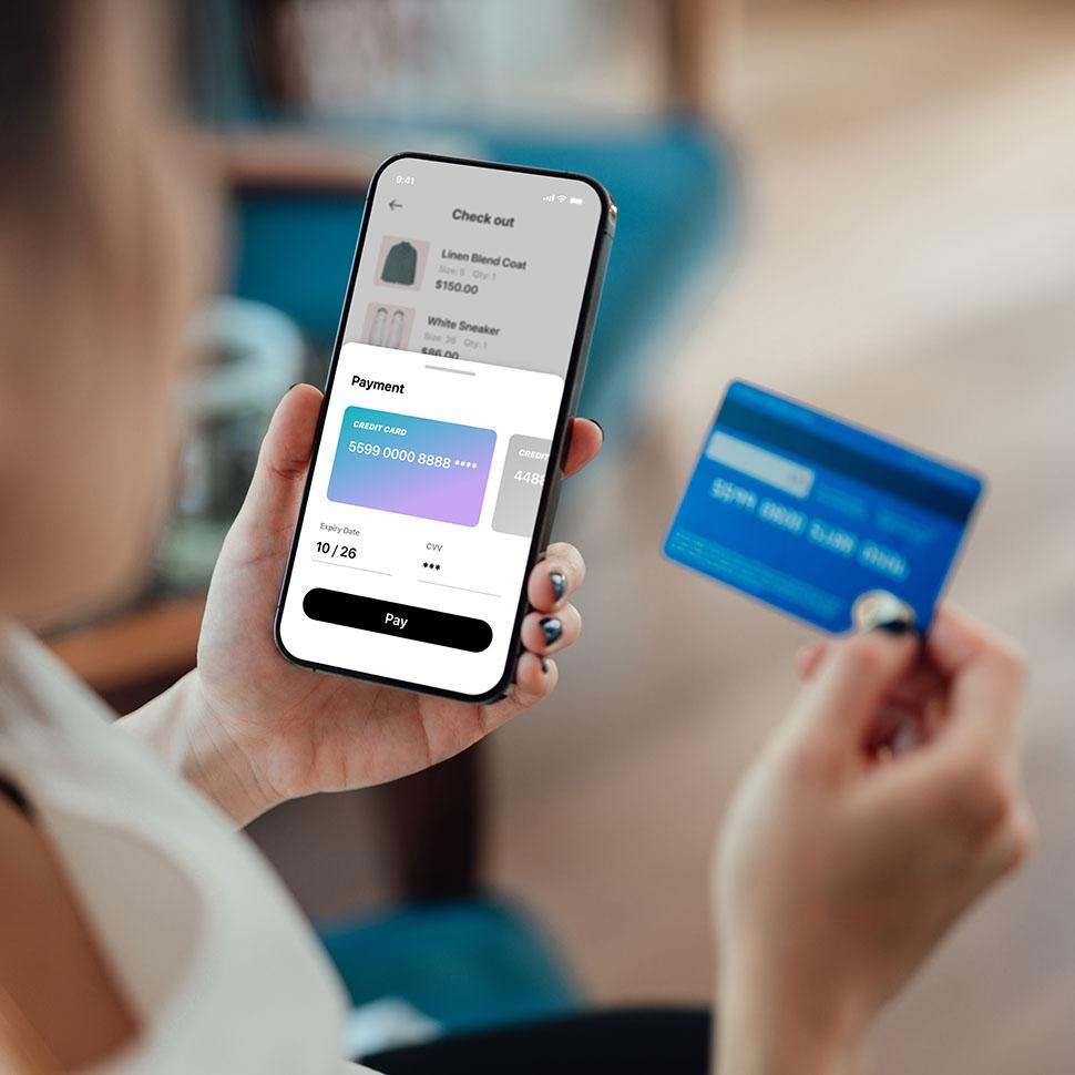 Woman purchasing product using credit card and phone.