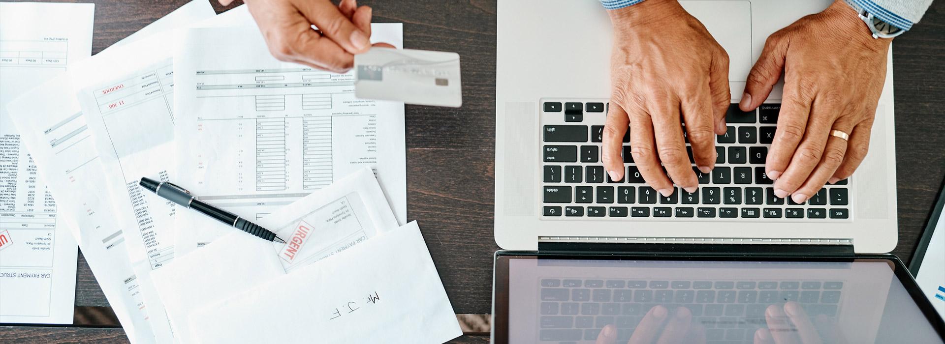 woman's hand holding credit men's hands typing on computer